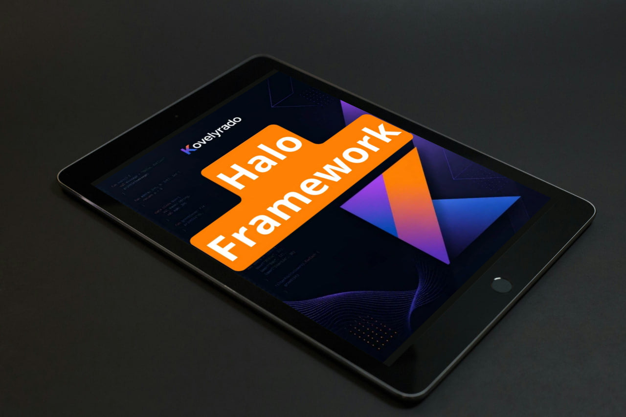 A black tablet angled on a dark surface, displaying a colorful screen with the text 'Koyepino Halo Framework' in orange and white over a dark abstract graphic.